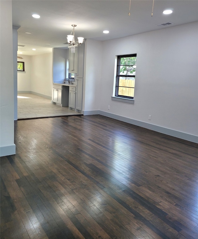 unfurnished room with dark wood-type flooring and a notable chandelier