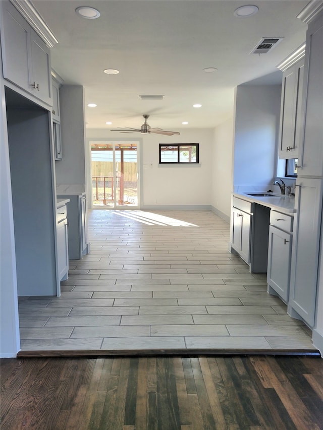 kitchen with light hardwood / wood-style floors, sink, and ceiling fan