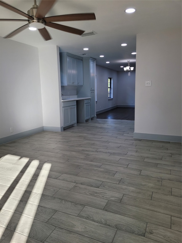 unfurnished living room with light hardwood / wood-style floors and ceiling fan with notable chandelier