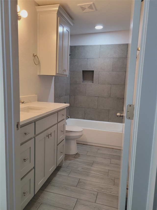 full bathroom with vanity, toilet, and tiled shower / bath combo