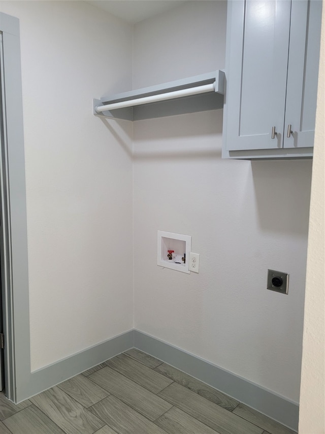 laundry area featuring hookup for an electric dryer, cabinets, light hardwood / wood-style flooring, and hookup for a washing machine