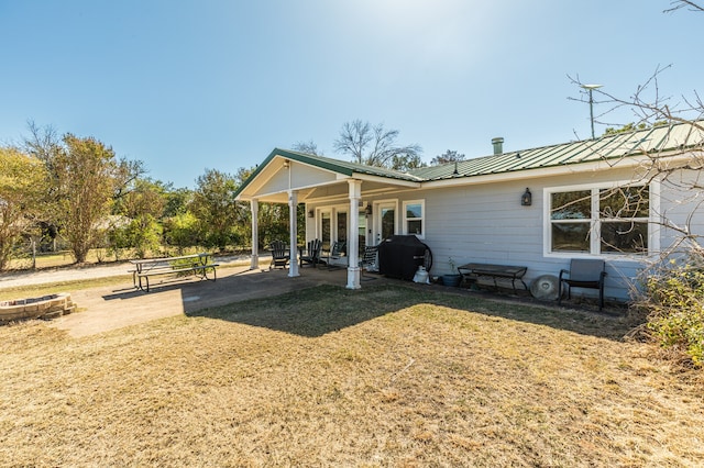 back of property with a patio area, a lawn, and ceiling fan