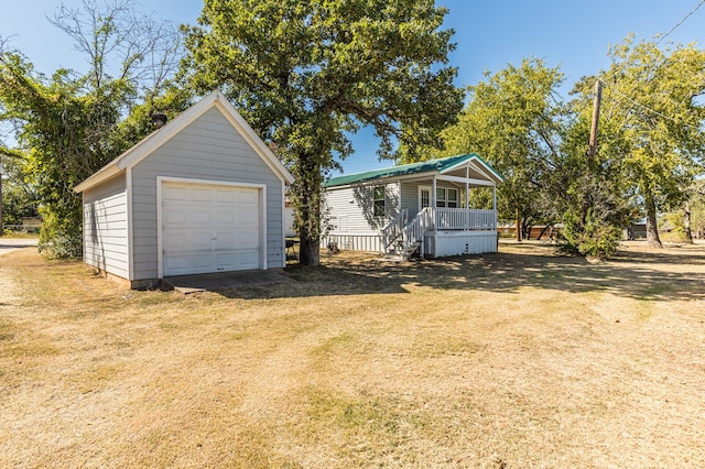 view of front of house featuring a front lawn, an outbuilding, and a garage