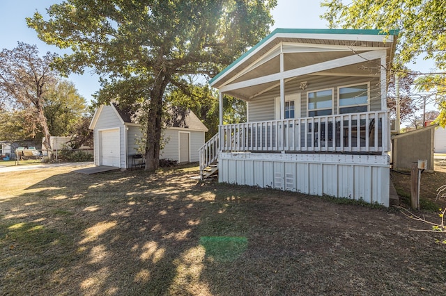 view of front of house featuring a shed, a garage, and a porch