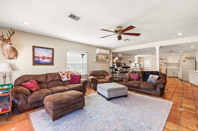 living room featuring a wall unit AC, light tile patterned floors, and ceiling fan