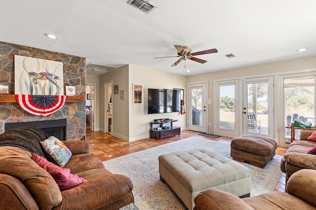 tiled living room with a fireplace and ceiling fan