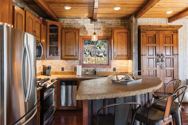 kitchen with dark hardwood / wood-style floors, wooden ceiling, a breakfast bar, decorative light fixtures, and appliances with stainless steel finishes