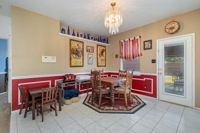 dining area with a chandelier and tile patterned flooring