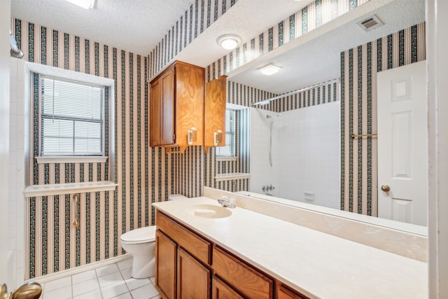 bathroom with a healthy amount of sunlight, tile patterned flooring, and a textured ceiling