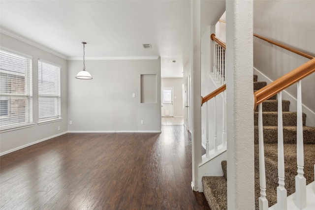 interior space with a wealth of natural light, crown molding, and hardwood / wood-style flooring