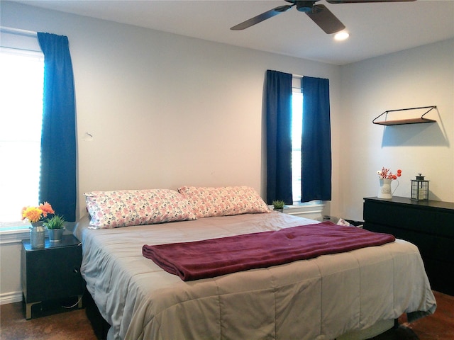 bedroom with ceiling fan and multiple windows