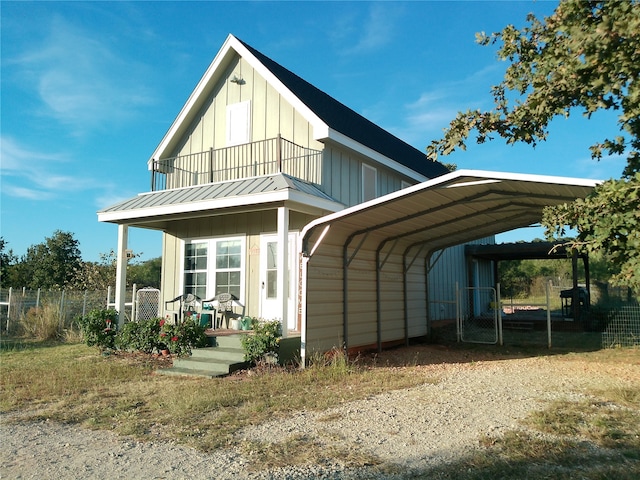 rear view of house featuring a balcony, a porch, and a carport