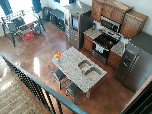 kitchen with appliances with stainless steel finishes and light stone counters