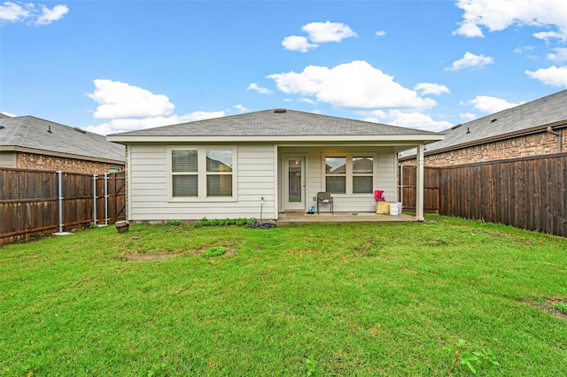 back of house with a yard and a patio