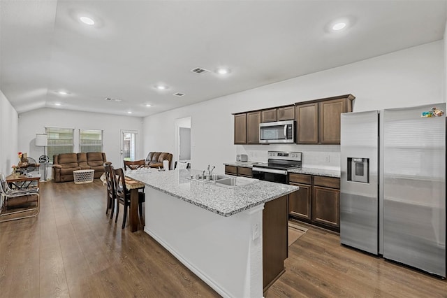 kitchen featuring a center island with sink, dark wood-type flooring, appliances with stainless steel finishes, and light stone countertops