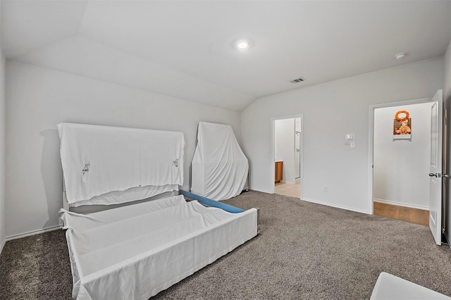 carpeted bedroom with lofted ceiling and connected bathroom