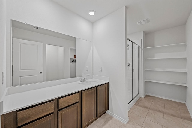 bathroom with vanity, tile patterned floors, and a shower with door