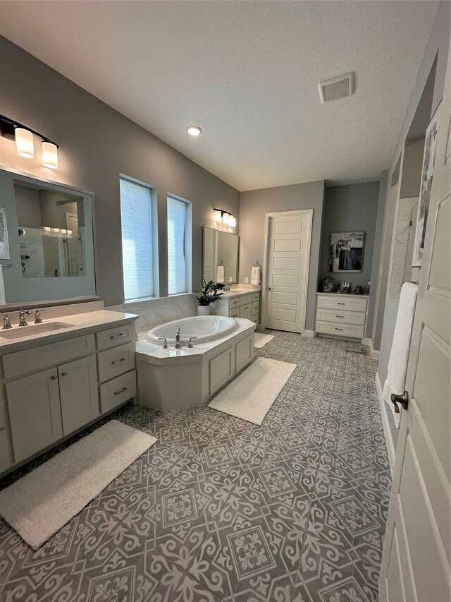 bathroom featuring separate shower and tub, tile patterned flooring, vanity, and a textured ceiling