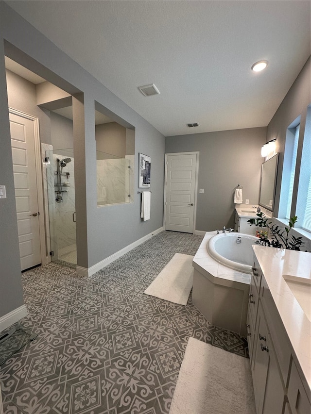 bathroom featuring plus walk in shower, tile patterned flooring, and vanity