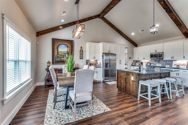 dining space featuring dark wood-type flooring, high vaulted ceiling, beamed ceiling, and sink