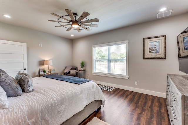 bedroom with dark hardwood / wood-style flooring and ceiling fan