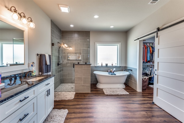 bathroom with vanity, shower with separate bathtub, wood-type flooring, and a wealth of natural light