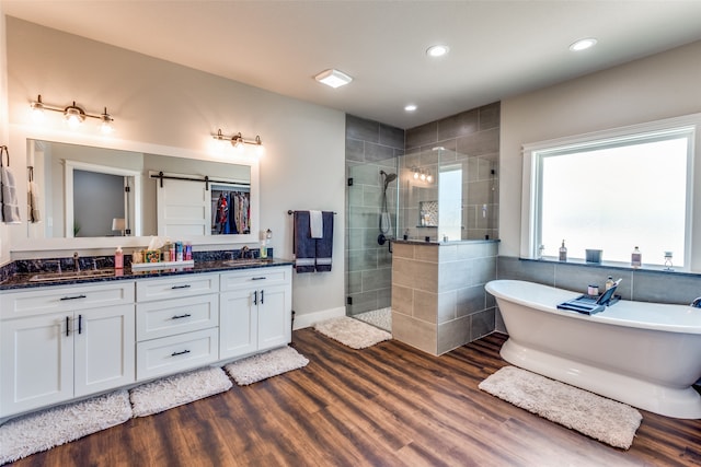 bathroom with vanity, independent shower and bath, and wood-type flooring