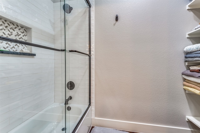 bathroom with shower / bath combination with glass door