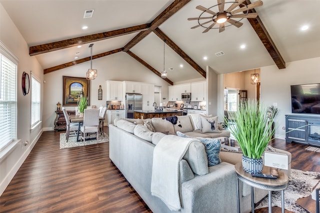 living room with a healthy amount of sunlight, high vaulted ceiling, ceiling fan, and dark hardwood / wood-style flooring