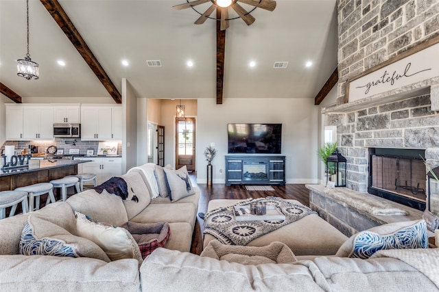 living room featuring dark wood-type flooring, ceiling fan, vaulted ceiling with beams, and a fireplace