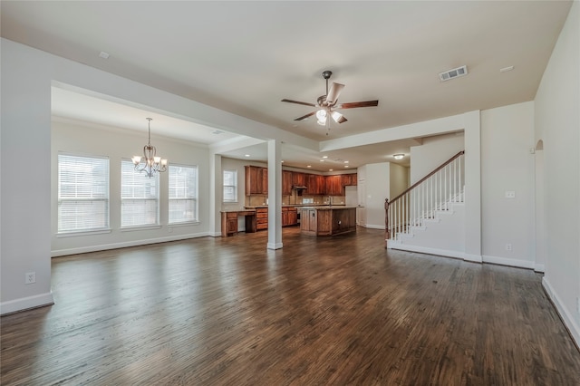 unfurnished living room with dark wood-type flooring, ornamental molding, and ceiling fan with notable chandelier