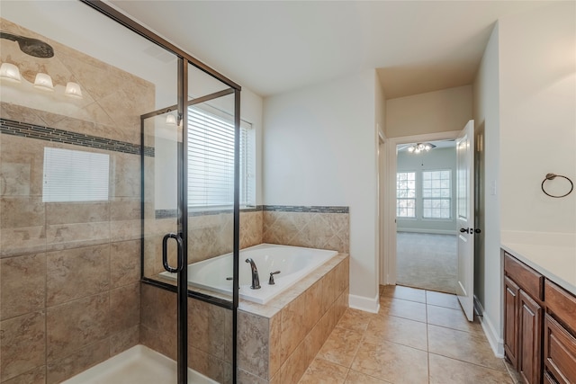 bathroom with vanity, independent shower and bath, a healthy amount of sunlight, and tile patterned flooring