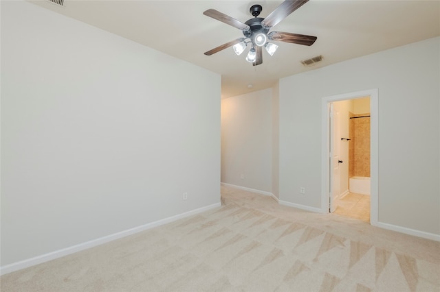 unfurnished bedroom with ceiling fan, light colored carpet, and ensuite bath