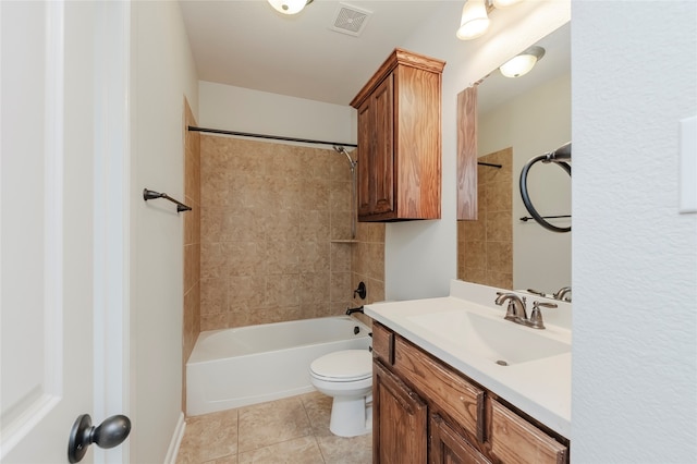 full bathroom featuring toilet, tiled shower / bath, vanity, and tile patterned floors