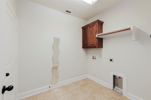 clothes washing area with hookup for a washing machine, hookup for an electric dryer, gas dryer hookup, light tile patterned floors, and cabinets