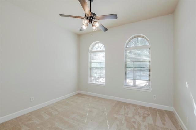 spare room with light carpet and ceiling fan