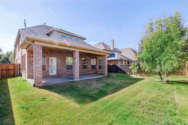 back of house with a patio and a lawn