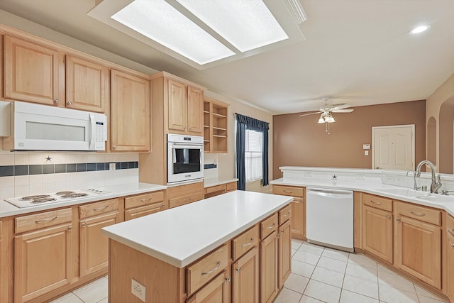 kitchen featuring a kitchen island, backsplash, light tile patterned flooring, sink, and white appliances