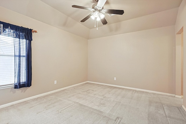 spare room featuring light carpet, lofted ceiling, and ceiling fan