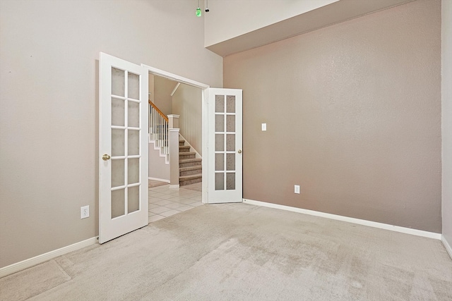 unfurnished room with french doors and light colored carpet