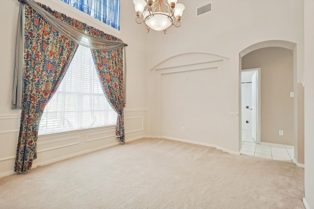 empty room featuring a chandelier and carpet floors