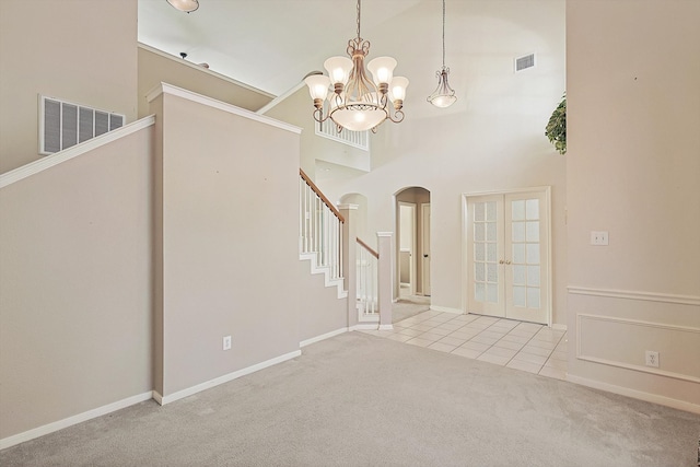 carpeted foyer entrance with french doors and a high ceiling