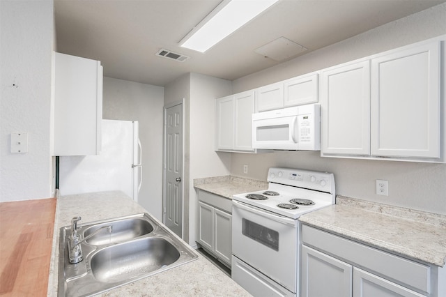 kitchen featuring sink, white cabinets, and white appliances