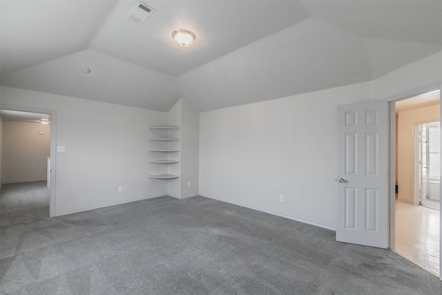 bonus room featuring lofted ceiling, carpet flooring, and built in features