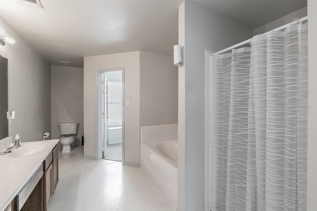 bathroom featuring vanity, a tub to relax in, and toilet