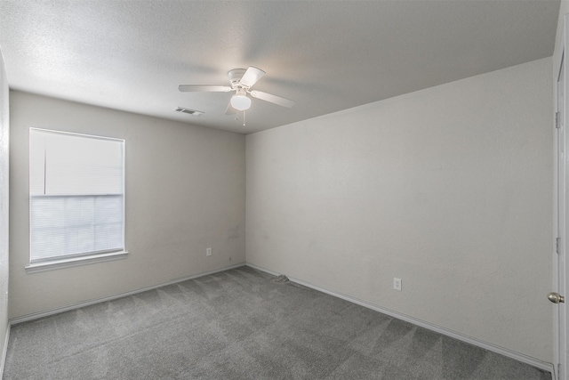 carpeted spare room featuring ceiling fan and a textured ceiling