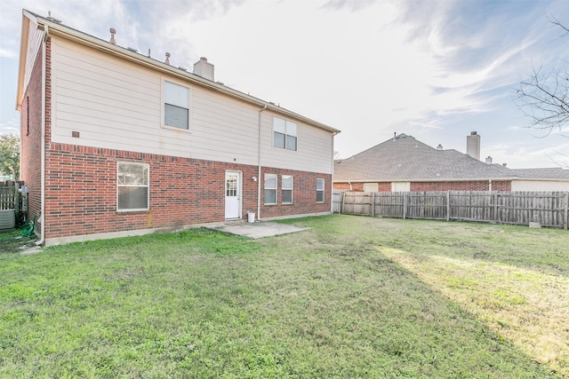 back of house featuring a lawn and a patio area