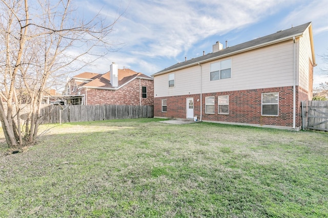 rear view of property featuring a patio area and a yard