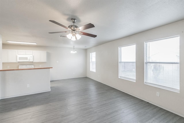 unfurnished living room featuring a textured ceiling, wood-type flooring, and ceiling fan with notable chandelier