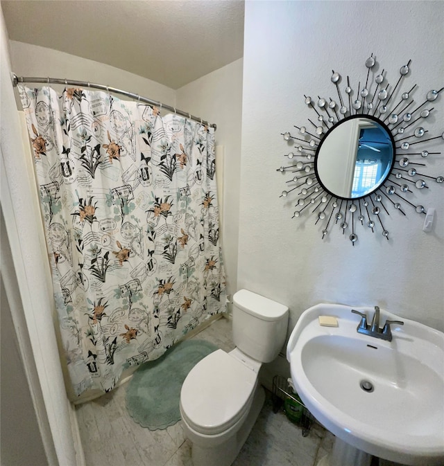 bathroom with toilet, a shower with curtain, and sink